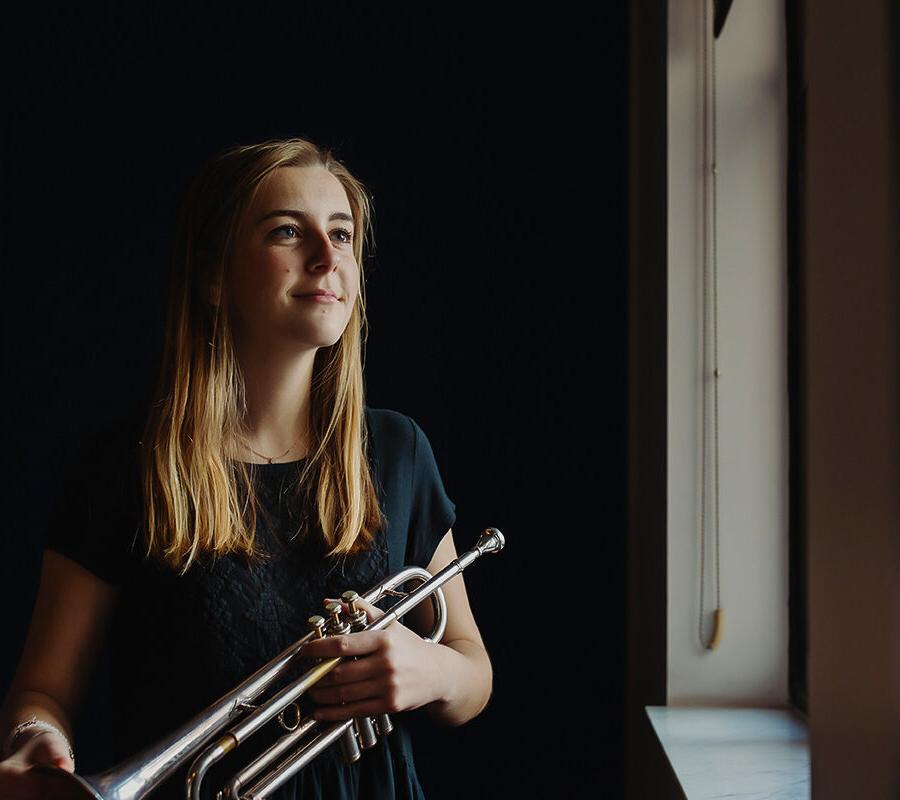 a student in the popular music degree holds a trumpet